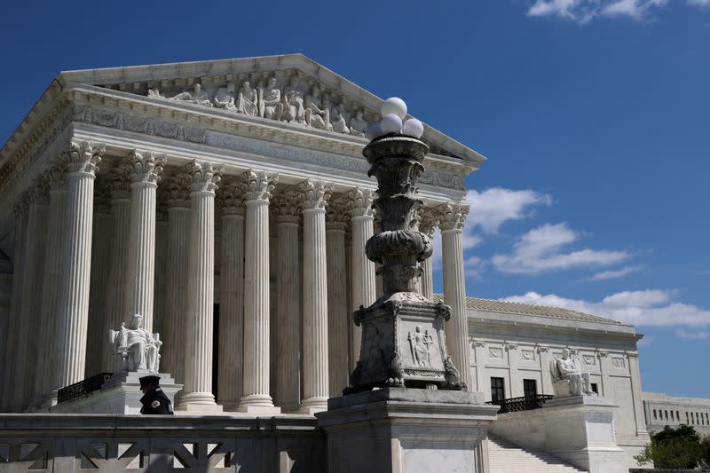 A police officer is mostly alone on the plaza in front of the U.S. Supreme Court building during the coronavirus disease (COVID-19) outbreak in Washington