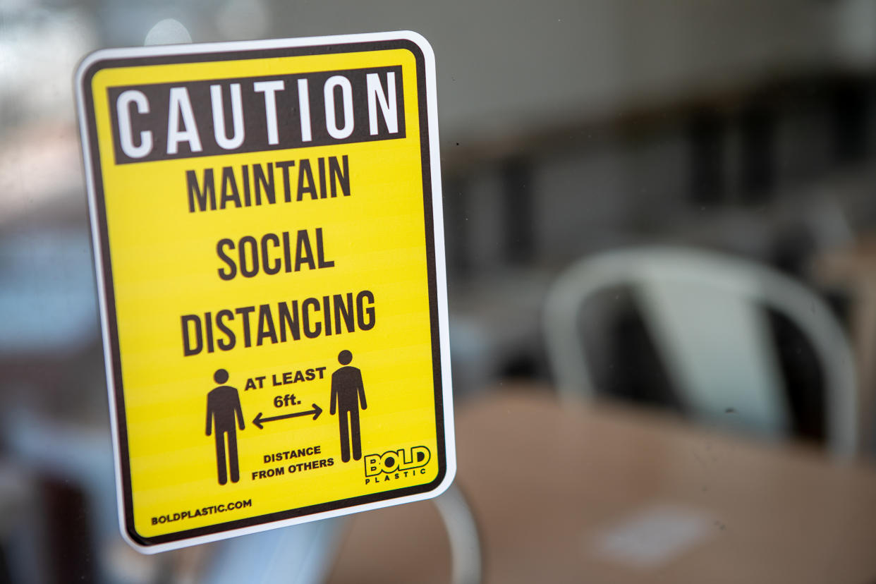 A social distancing sign is displayed in the window of a business in Miami, Florida, U.S., on Wednesday, July 8, 2020. (Jayme Gershen/Bloomberg via Getty Images)