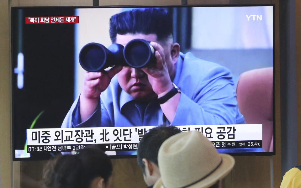 FILE - In this Aug. 2, 2019, file photo, people watch a TV showing a file footage of North Korean leader Kim Jong Un during a news program at the Seoul Railway Station in Seoul, South Korea. North Korea on Saturday, Aug. 10, 2019, extended a recent streak of weapons display by firing projectiles twice into the sea, according to South Korea's military. The sign reads "North Korea launches frequently." (AP Photo/Ahn Young-joon, File)
