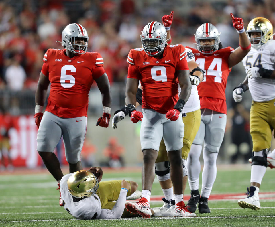 Sep 3, 2022; Columbus, Ohio; Notre Dame Fighting Irish quarterback Tyler Buchner (bottom) after being tackled for a loss by Ohio State Buckeyes defensive end Zach Harrison (9) during the third quarter at Ohio Stadium. Joseph Maiorana-USA TODAY Sports
