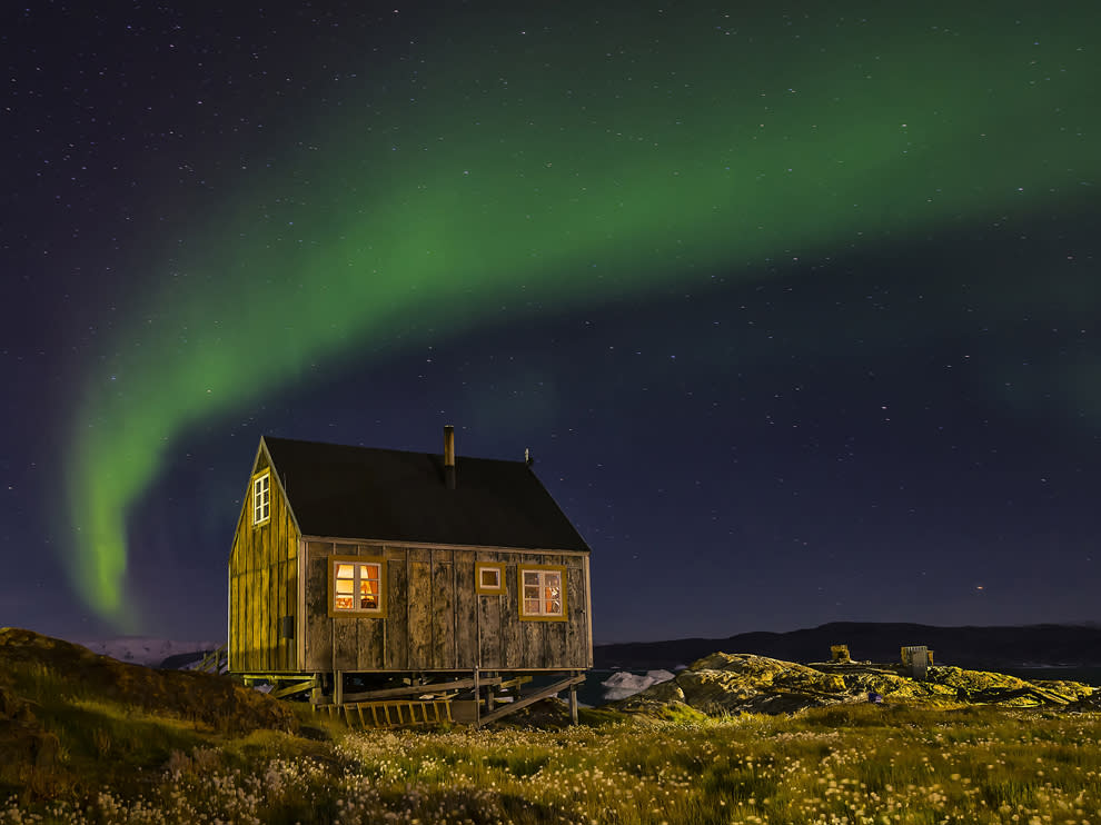 Aurora borealis over the village of Tinit, Greenland. The house belongs to a local, but you can rent small houses in this village of about 250 people. It is accessible by boat during the summer and dog sleds during the winter.