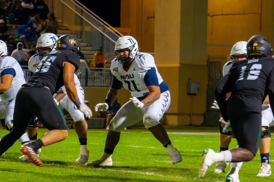 Northern Arizona redshirt senior offensive lineman PJ Poutasi (71) prepares for a tackle against Cal Poly on November 20, 2021.