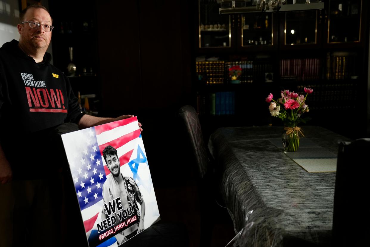 Daniel Rothner poses by a picture of his friendÕs son, who was kidnapped on October 7th. Rothner, shown here on Wednesday, April 17, 2024, said he and his family will keep an empty chair at their table during their Passover seder in honor of those who remain kidnapped.