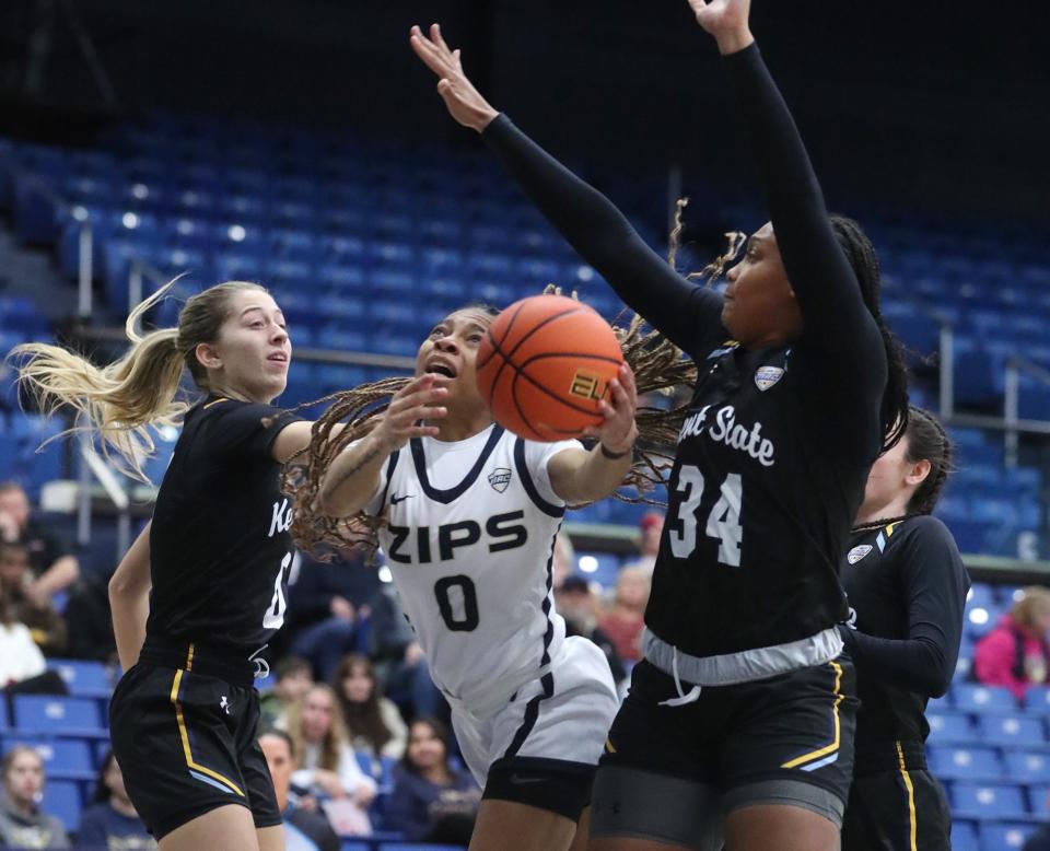 Akron's Kaia Woods, center, goes to the basket between Kent State's Kaley Perkins and Janae Tyler on Saturday in Akron.