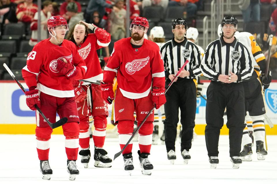(From left) Red Wings left wing Lucas Raymond, left wing Tyler Bertuzzi, and defenseman Filip Hronek react after the Wings' 7-2 loss to the Penguins on Saturday, April 23, 2022, at Little Caesars Arena.