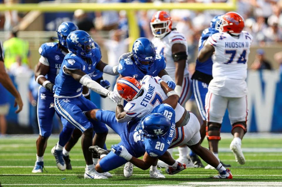 Florida running back Trevor Etienne (7) is tackled by Kentucky linebacker Keaten Wade (20) and defensive back Jordan Robinson (28) during Saturday’s game at Kroger Field. Etienne was held to 29 yards on 11 carries.
