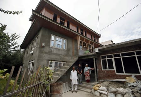 Mohammad Maqbool Malik, Haseena and Danish, parents and brother of Uzair Maqbool Malik pose for a picture outside their house in south Kashmir's Shopian
