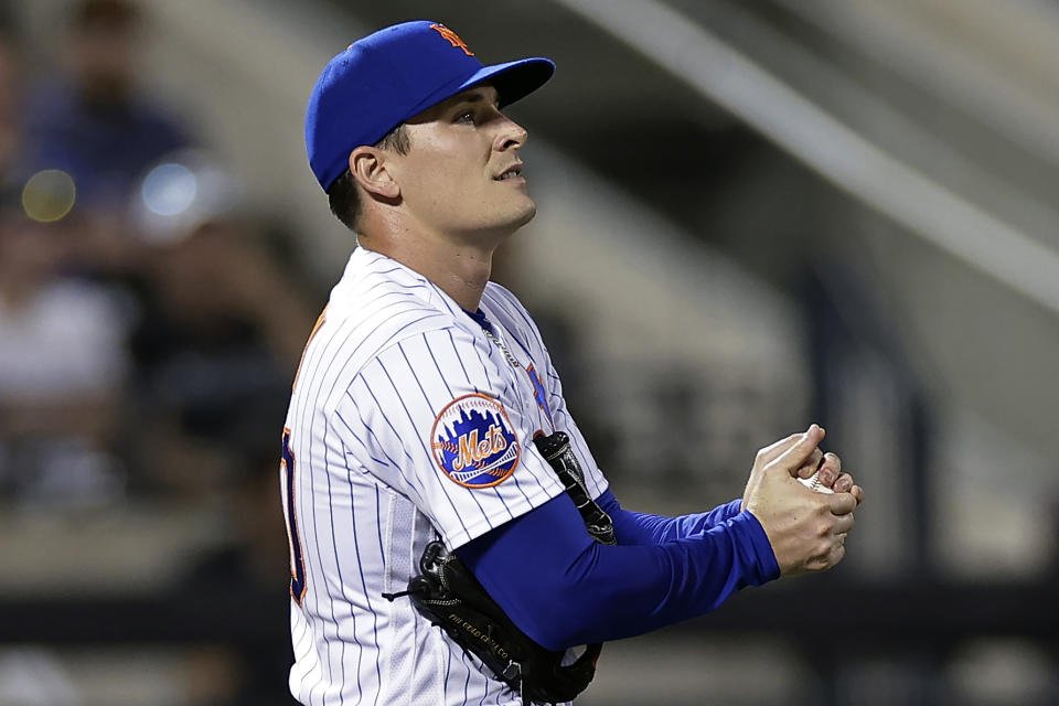 New York Mets pitcher Drew Smith rubs a new ball after giving up a home run to Texas Rangers' during the seventh inning of a baseball game Tuesday, Aug. 29, 2023, in New York. (AP Photo/Adam Hunger)