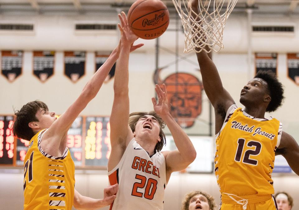 Green’s Brady Rollyson goes up between Walsh Jesuit’s Sean Spicer (21) and Keith Rivers on Sunday, Jan. 15, 2023, at Hoover High School.