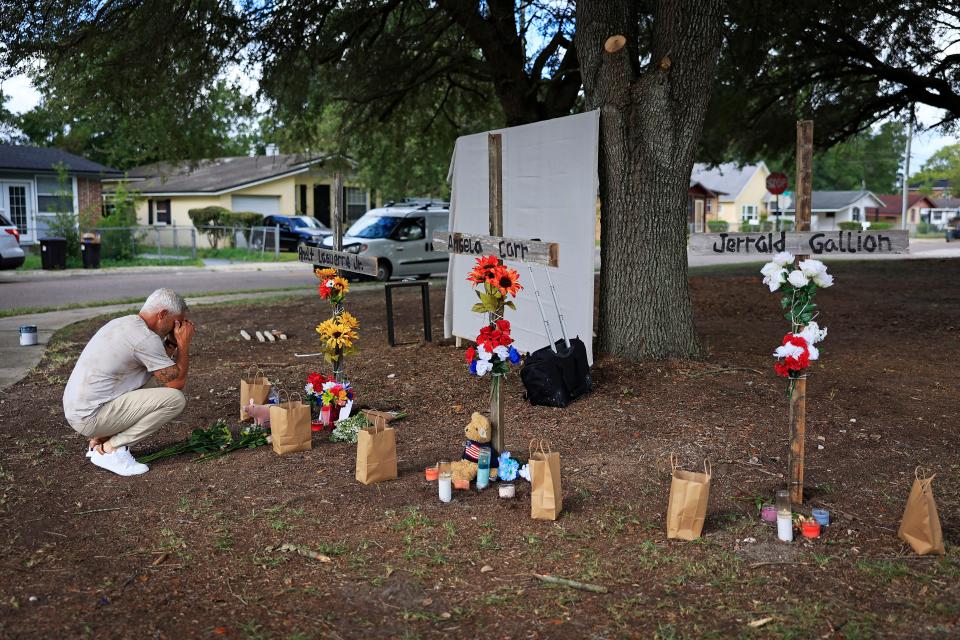 Will Walsh of Nocatee prays Monday in front of three crosses representing the Aug. 26 shooting victims near the site of the Dollar General store in Jacksonville.