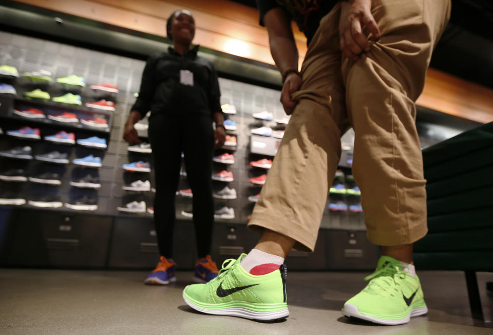 A man tries on shoes in the Nike store in Santa Monica, California, September 25, 2013. NIKE, Inc. plans to release its first quarter fiscal 2014 financial results on Thursday, September 26, 2013.  REUTERS/Lucy Nicholson (UNITED STATES - Tags: BUSINESS SPORT)