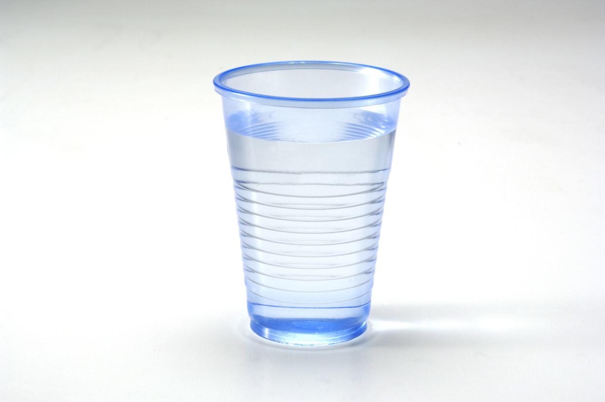 Glass of water in a plastic blue cup