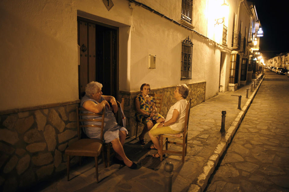 Women sit on chairs outside their houses to avoid the heat on a hot summer night in Ronda, near Malaga, southern Spain late August 27, 2010. Temperatures were forecast to exceed 44 degrees Celsius (111 F) in many parts of Spain on Friday, with peaks of 42 to 44 degrees (107-111 F) in the south. Picture taken August 27, 2010. REUTERS/Jon Nazca (SPAIN - Tags: SOCIETY ENVIRONMENT)