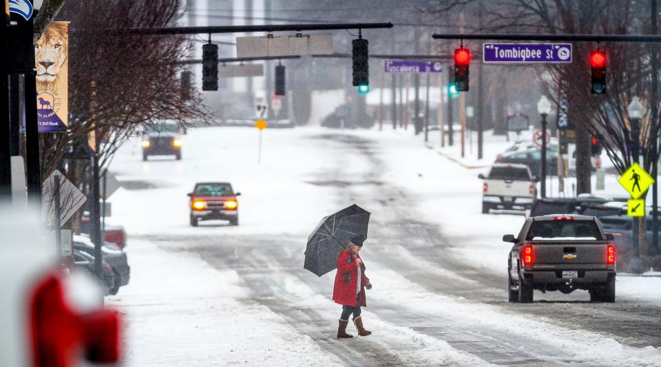 A man crosses North Pine Street as motorists navigate an ice and snow covered road, Thursday, Jan. 18, 2024 in downtown Florence, Ala.. (Dan Busey/The TimesDaily via AP) (AP)