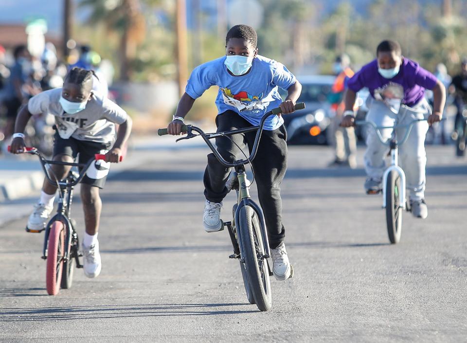 Kids race each other during a community bmx bike rally at the James O. Jessie Desert Highland Unity Center in Palm Springs, February 12, 2021.