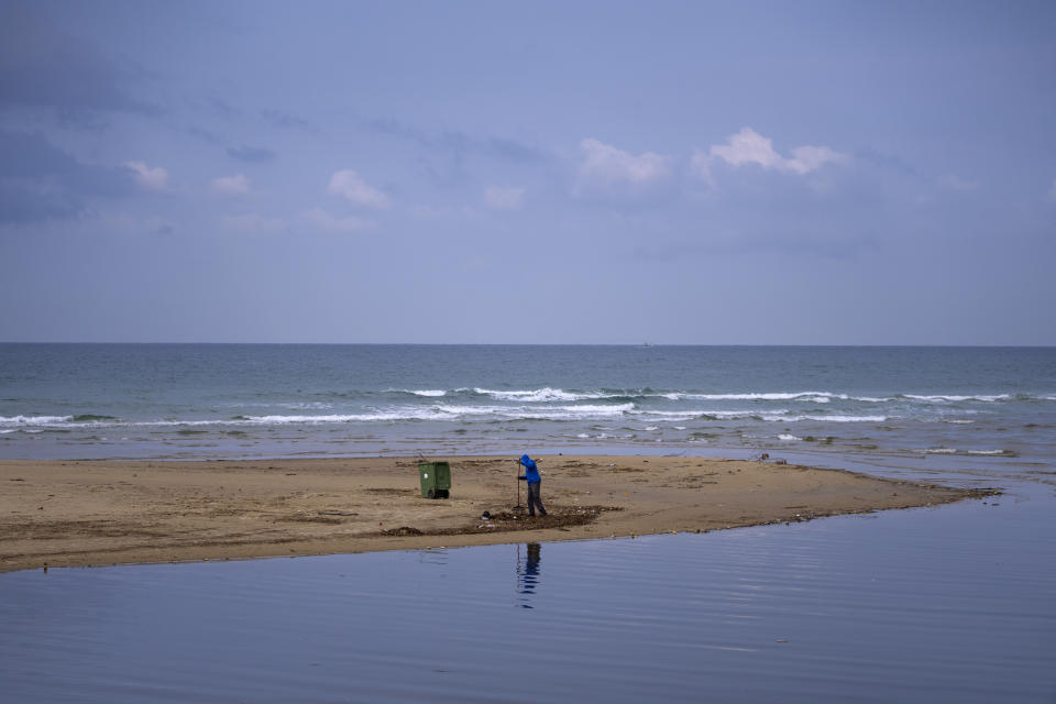 A Tel Aviv's municipality worker cleans the beach from plastic waste, in Tel Aviv, Monday, Jan. 9, 2023. Israel's new government is in the process of repealing a new tax on single-use plastics. Ultra-Orthodox Jews, who have large families and use large quantities of disposable cups, plates and cutlery, say the tax unfairly targeted them. (AP Photo/Oded Balilty)