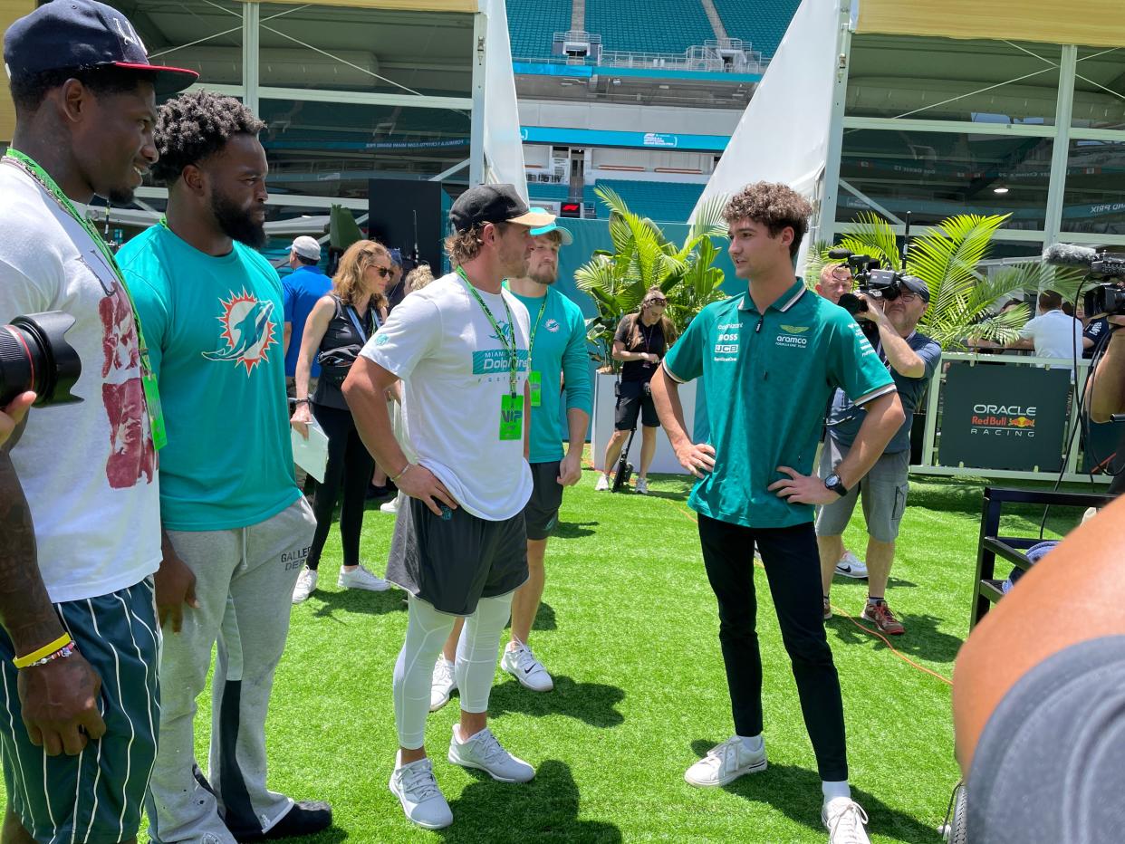 Jak Crawford, driver for Aston Martin in Formula 1, talks racing and football with members of the Dolphins. From left, they are cornerback Siran Neal, linebacker David Long, receiver Braxton Berrios and receiver Mathew Sexton.