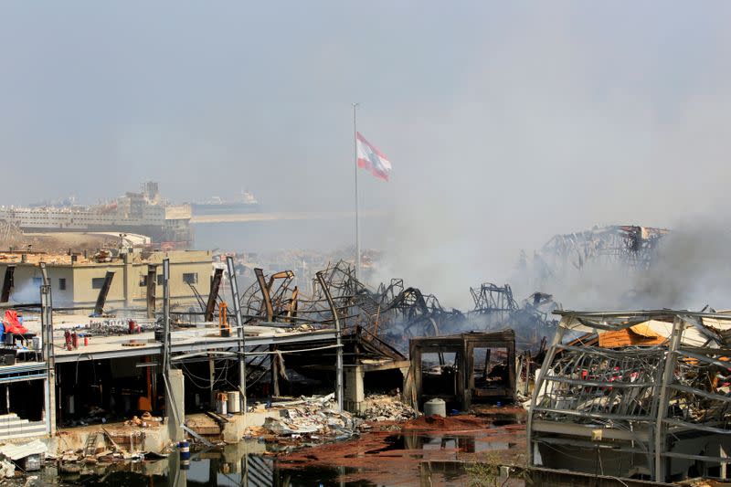 A Lebanese flag flutters amid the smoke at the site of a fire that broke out at Beirut's port yesterday