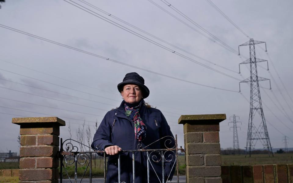 Suzanne Evans standing at the gates of her childhood home in West Tilbury