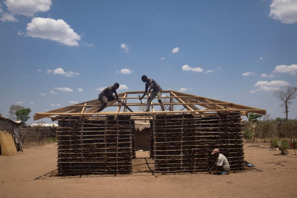 Workers from UNHCR partner Caritas build a new house for an internally displaced family at the Corrane IDP site (Hélène Caux/UNHCR)