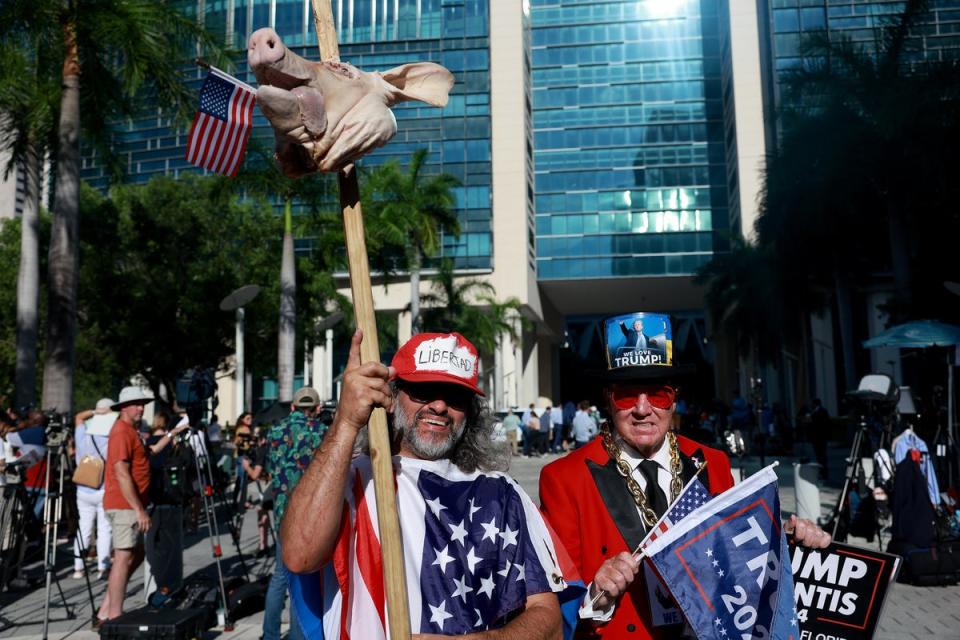 Osmany Estrada (izquierda) sostiene una cabeza de cerdo mientras él y Gregg Donovan se reúnen ante el juzgado federal de los Estados Unidos Wilkie D. Ferguson Jr. (Getty Images)