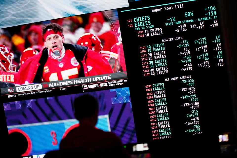 A person gambles as betting odds for NFL football’s Super Bowl are displayed on monitors at the Circa resort and casino sports book (AP)