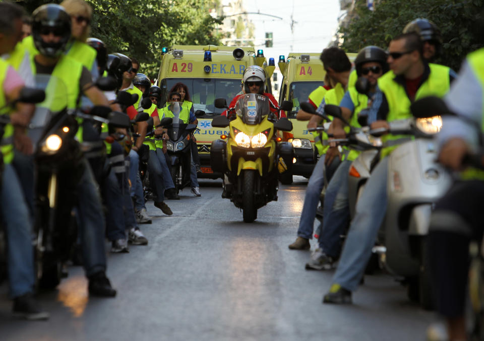 Greek paramedics and first aid workers on motorbikes and in ambulances take part in a protest against pay and funding cuts, outside the Health Ministry in Athens, on Tuesday, Oct. 16, 2012. Greece has been surviving on emergency loans from eurozone countries and the International Monetary Fund for more than two years. It is currently locked in protracted negotiations with rescue creditors for a major new austerity package that is set to take the country into a sixth year of recession in 2013. (AP Photo/Thanassis Stavrakis)