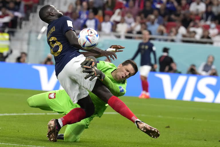 El defensor francés Dayot Upamecano choca con el arquero polaco Wojciech Szczęsny durante el partido entre ambas selecciones por los octavos de final de Qatar 2022; el futbolista galo fue el tercer infectado por un virus y ya se reincorporó a las prácticas