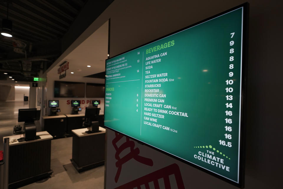 A sign inside Climate Pledge Arena displays beverage and snack prices, Wednesday, Oct. 20, 2021, during a media tour ahead of the NHL hockey Seattle Kraken's home opener Saturday against the Vancouver Canucks in Seattle. The historic angled roof of the former KeyArena was preserved, but everything else inside the venue, which will also host concerts and be the home of the WNBA Seattle Storm basketball team, is brand new. (AP Photo/Ted S. Warren)