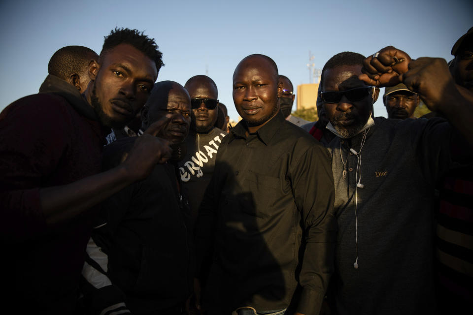 Activist Mamadou Drabo, leader of the Save Burkina Faso movement, center, announces to the crowd gathered Place de la Nation that Lt. Col. Paul Henri Sandaogo Damiba has taken the reins of the country in Ouagadougou Monday Jan. 24, 2022. More than a dozen mutinous soldiers declared Monday on state television that a military junta now controls Burkina Faso after they detained the democratically elected president following a day of gun battles in the capital. (AP Photo/Sophie Garcia)