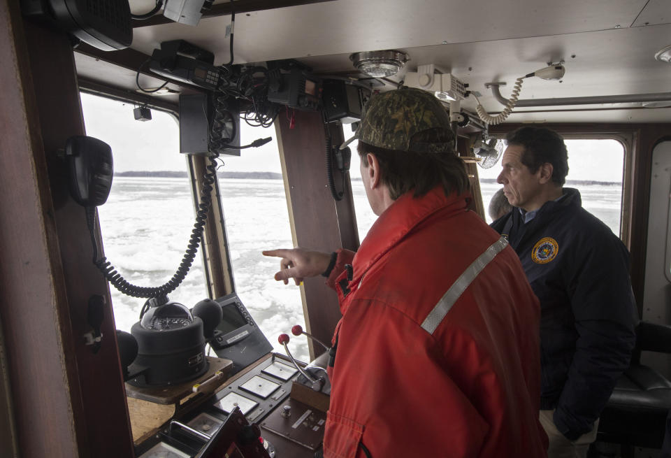 New York Gov. Andrew Cuomo, right, joins Captain Brian MacLaren, left, on an ice breaking mission aboard the New York Power Authority's ice breaker William Latham on the Niagara River, to keep water intakes clear, Monday, Feb. 25, 2019, in Niagara Falls, N.Y. Giant chunks of ice spilled over the banks of the Niagara River across from Buffalo on Sunday, creating a jagged, frosty barrier between the river and a scenic road and high winds howled through much of the nation's eastern half for a second day Monday. (John Hickey/Buffalo News via AP, Pool)