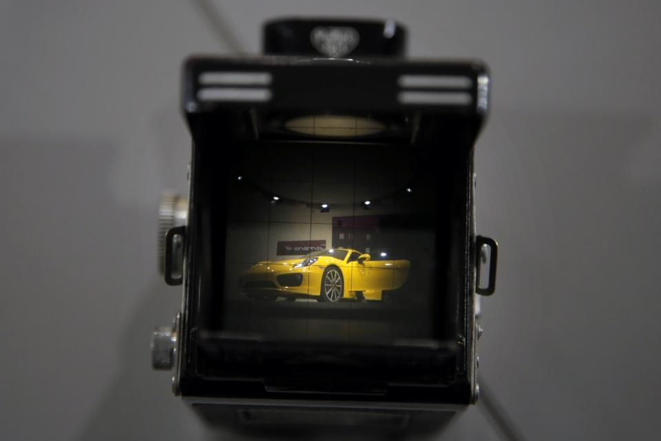 The new Porsche Cayman is seen through the viewfinder of a vintage TLR camera at the LA Auto Show in Los Angeles, Thursday, Nov. 29, 2012. (AP Photo/Jae C. Hong)