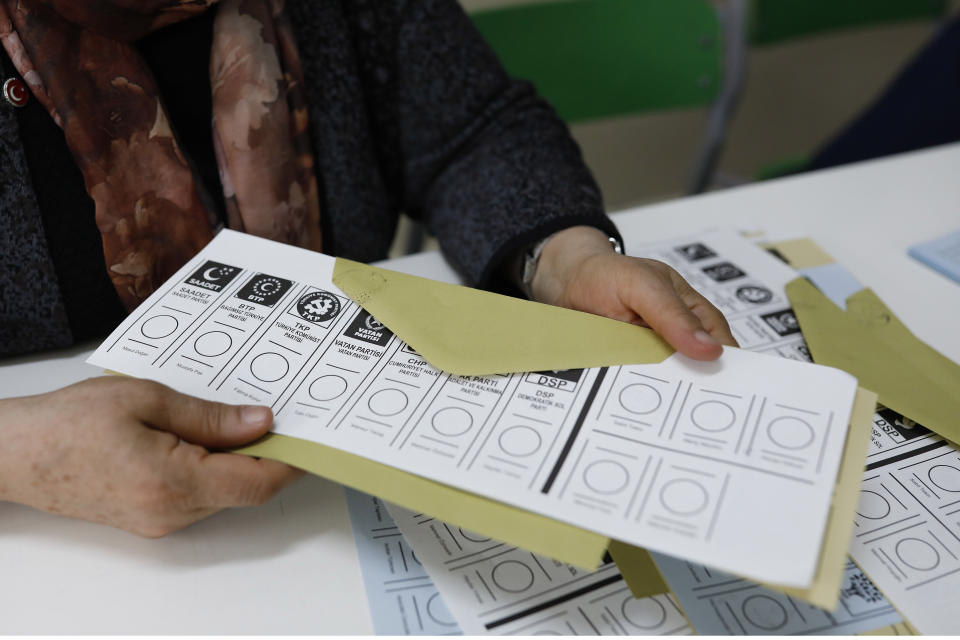 An official female holds a ballot voting paper at a polling station during the municipal elections in Ankara, Turkey, Sunday, March 31, 2019. Turkish citizens have begun casting votes in municipal elections for mayors, local assembly representatives and neighborhood or village administrators that are seen as a barometer of Erdogan's popularity amid a sharp economic downturn. (AP Photo/Burhan Ozbilici)