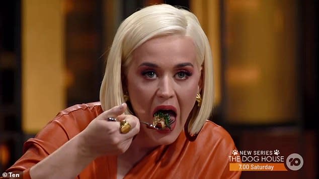 Katy Perry wearing an orange dress eating in the MasterChef kitchen