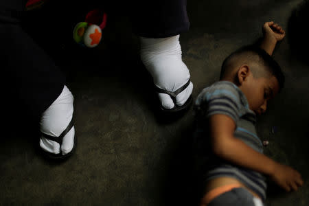 FILE PHOTO: Elimenes Fuenmayor, 65, a patient with kidney disease, waits for the electricity to return, as his grandson lays beside him on the floor, in his house during a blackout in Maracaibo, Venezuela April 11, 2019. REUTERS/Ueslei Marcelino