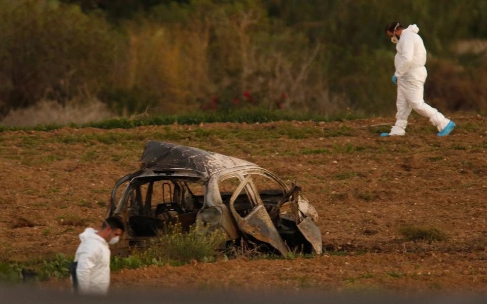 Forensic experts examine the scene of the car bombing that killed Daphne Caruana Galizia