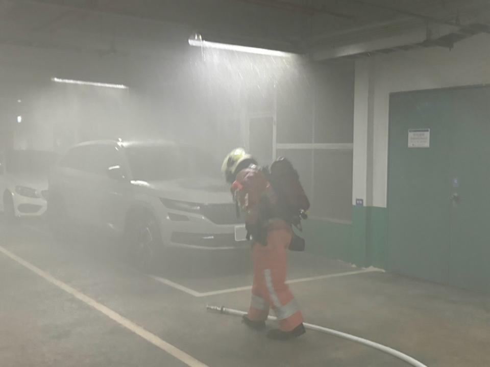 竹科晶元光電停車場火警，火勢很快撲滅但消防人員仍冒濃煙進行檢測確保安全。（圖：消防局提供）