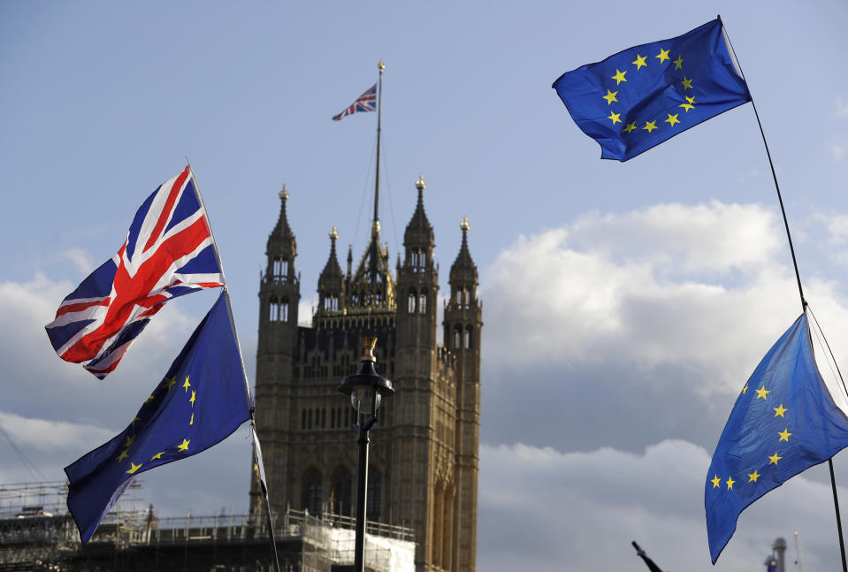 Union Jacks and EU flags fly over Britain's Parliament in London, Saturday, Oct. 19, 2019. In a major blow to British Prime Minister Boris Johnson, U.K. lawmakers voted Saturday to postpone a decision on whether to back his Brexit deal with the European Union, throwing a wrench into government plans to leave the bloc at the end of this month. (AP Photo/Kirsty Wigglesworth)