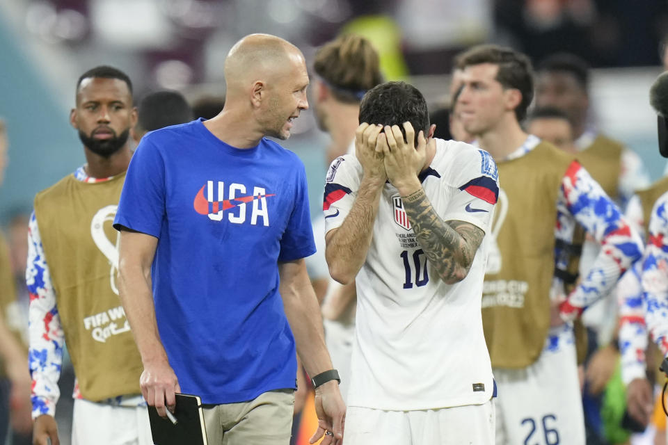 Head coach Gregg Berhalter of the United States, and Christian Pulisic of the United States leave the pitch at the end of the World Cup round of 16 soccer match between the Netherlands and the United States, at the Khalifa International Stadium in Doha, Qatar, Saturday, Dec. 3, 2022. (AP Photo/Francisco Seco)