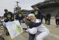 Kollia Safford, from Delhi N.Y., hugs his godfather, Communications Specalist, Christopher Payne, after he disembarked from the nuclear aircraft carrier Harry S. Truman at Naval Station Norfolk in Norfolk, Va., Friday, April 18, 2014. The Truman Strike Group arrive after a 9-month deployment to the Middle East. (AP Photo/Steve Helber)