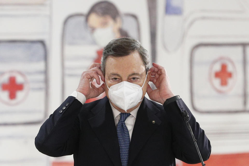 Italian Premier Mario Draghi puts on his face mask after speaking during a visit to a COVID-19 vaccination center, at the Rome Leonardo Da Vinci airport, in Fiumicino, Friday, March 12, 2021. Italy is tightening anti-COVID-19 restrictions for Easter weekend as infection numbers steadily climb and many hospitals warn that they are running out of ICU beds for coronavirus patients. Premier Mario Draghi’s government decided at a Cabinet meeting Friday that the entire nation will be under strict ‘’red zone’’ rules Saturday through Monday, April 3-5, which straddles Easter Sunday. (Guglielmo Mangiapane/Pool Photo via AP)