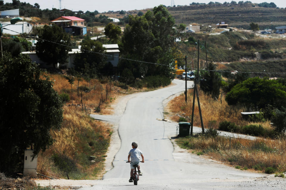 A boy rides his bicycle in the Israeli settlement of Havat Gilad in the occupied West Bank