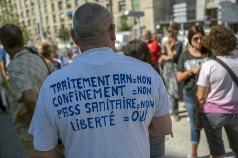 Un opposant au  pass sanitaire et à la vaccination manifeste avec d'autres soignants devant l'hôpital de la Timone à Marseille, le 5 août 2021 - Christophe SIMON © 2019 AFP