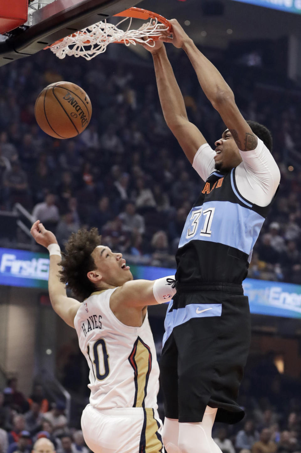 Cleveland Cavaliers' John Henson (31) dunks next to New Orleans Pelicans' Jaxson Hayes (10) during the first half of an NBA basketball game Tuesday, Jan. 28, 2020, in Cleveland. (AP Photo/Tony Dejak)