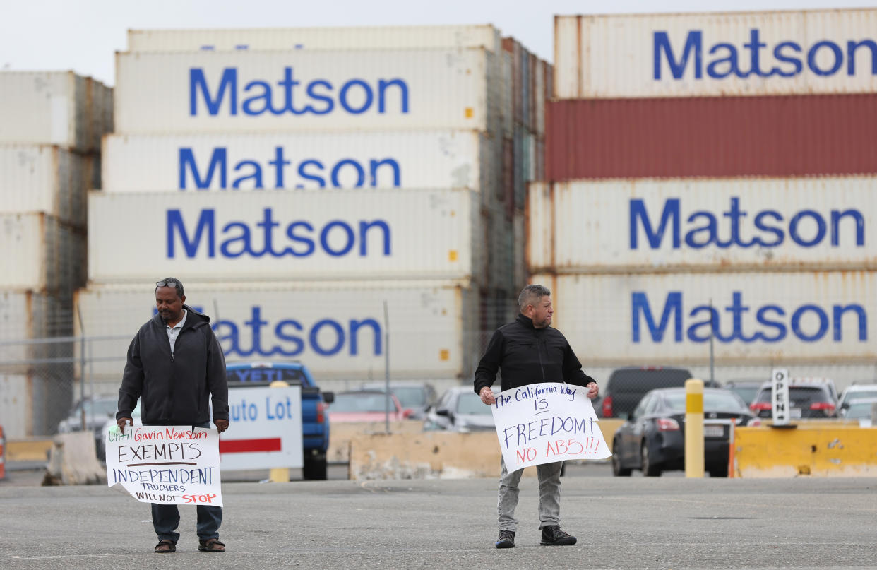 Truck drivers hold signs as they block the entrance to the Matson terminal at the Port of Oakland on July 21, 2022 in Oakland, California. (Photo by Justin Sullivan/Getty Images)
