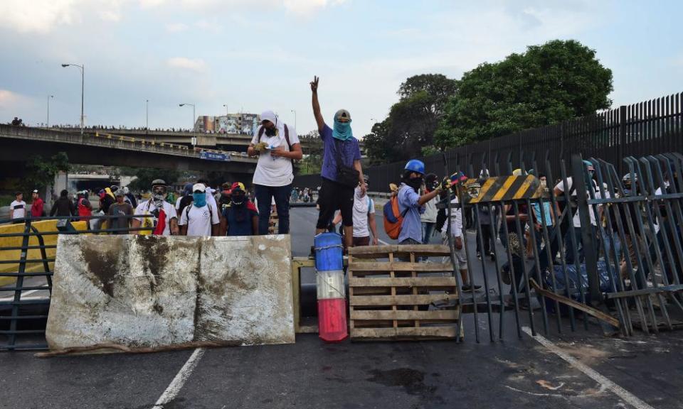 Venezuelan opposition activists stand behind a barricade set up during a demonstration in Caracas.