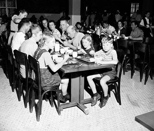 Children and adult immigrants detained at Ellis Island sit down to eat their noontime meal in New York City, June 12, 1947.