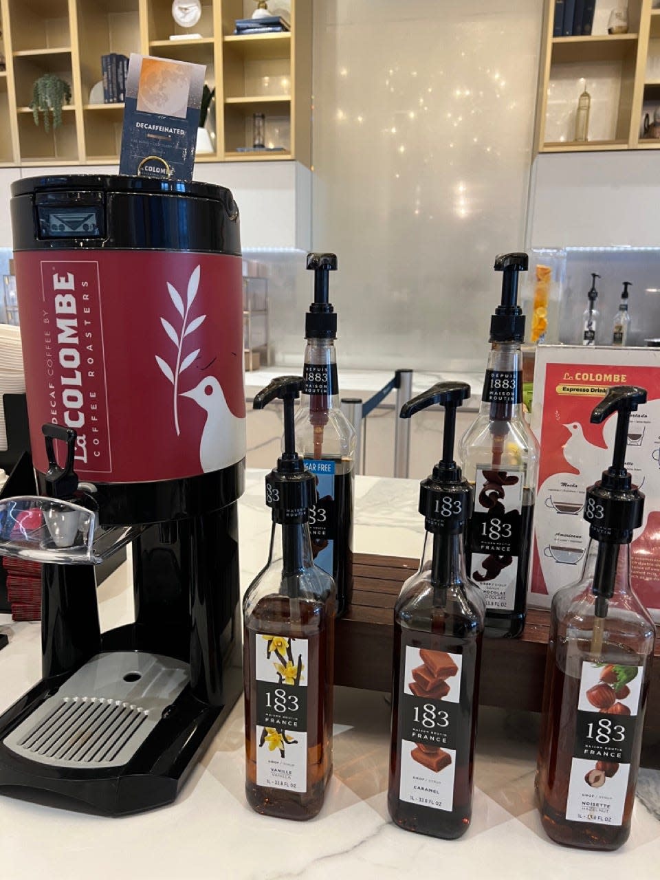 La colombe coffee in a large dispenser next to syrups