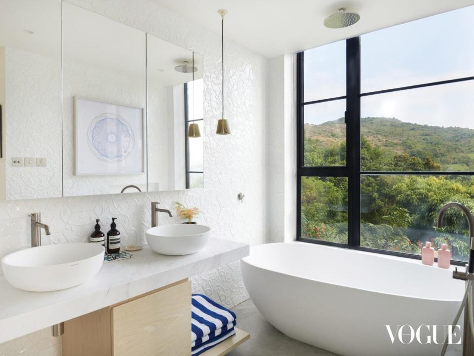 The spacious bathroom has its own serene view, with a bathtub by Infinite and Bramah Lights by Michael Young home. 