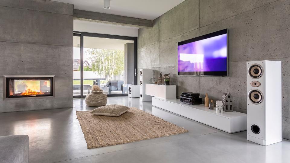 Tv living room with window, fireplace and concrete wall effect.